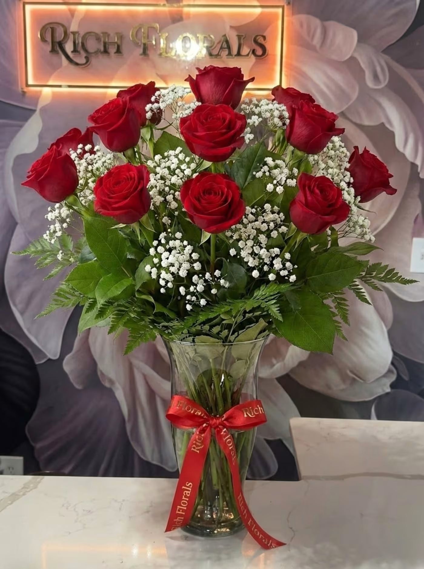 Long stemmed red roses with baby's breath in a vase by Rich Florals, Woodbridge NJ